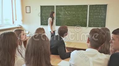 女学生在课堂上举手回答。 俄罗斯学校。